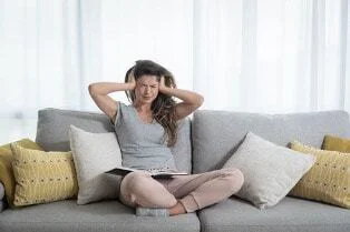 An image of a person dealing with a loud HVAC system.