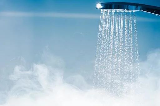Hot shower water running into a thick steam